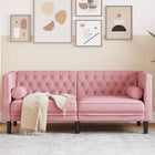 Two-seater Chesterfield-style sofa and velvet pink bolsters