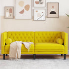 Two-seater Chesterfield-style sofa and velvet bolsters in yellow